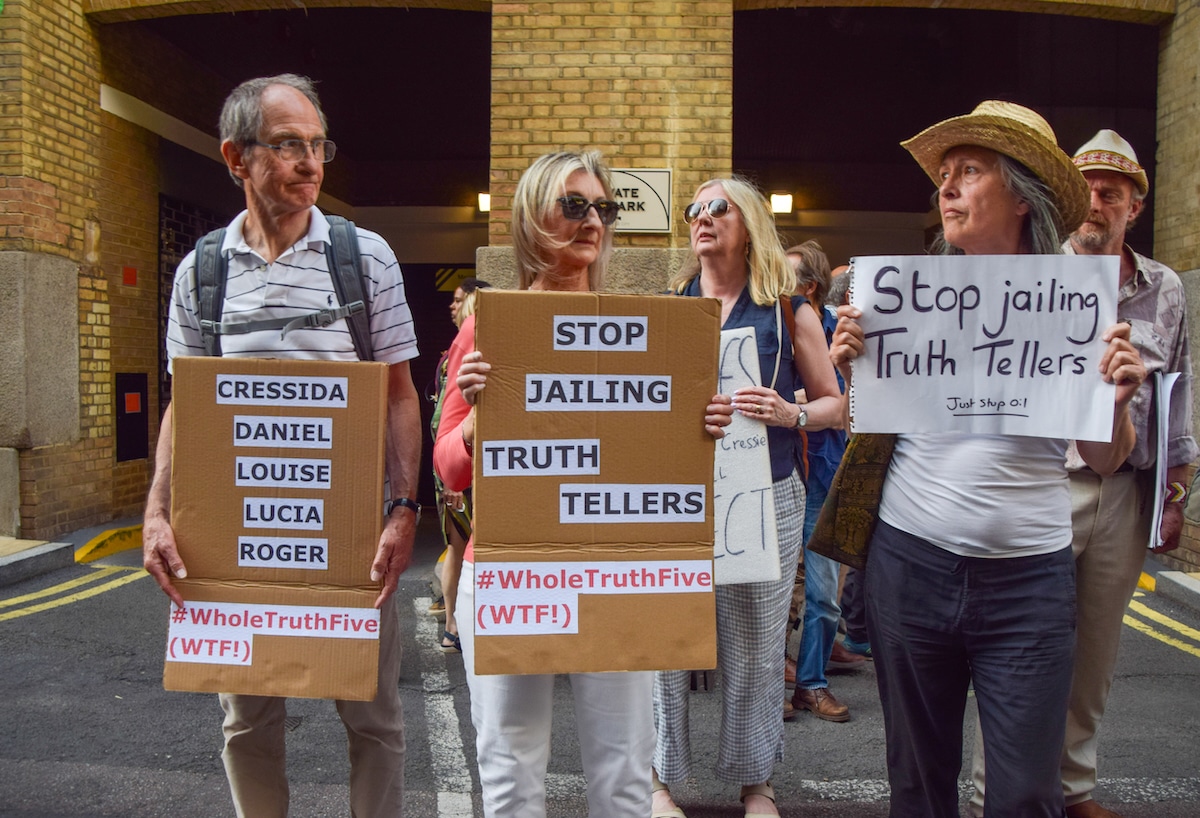 Protesters hold placards in support of the jailed climate activists outside Southwark Crown Court in London