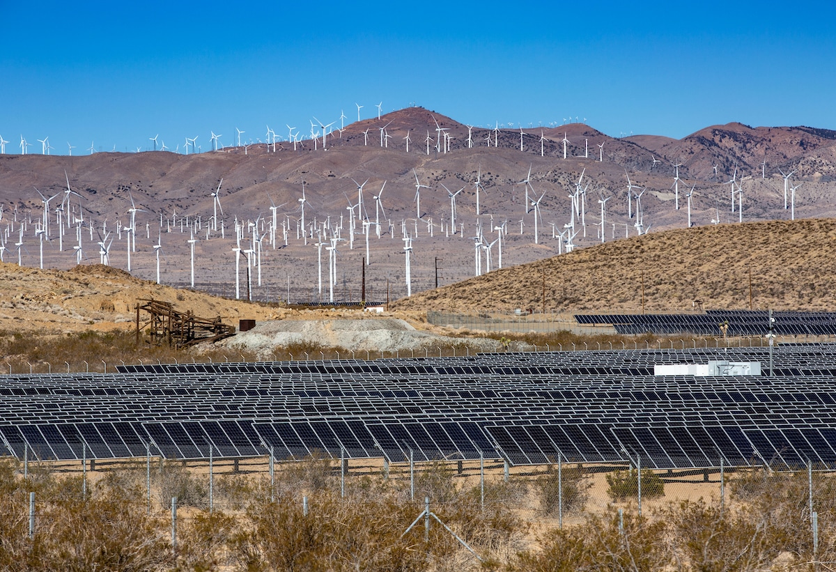 A large array of solar panels and wind turbines supplying power to the electricity grid in Mojave, California