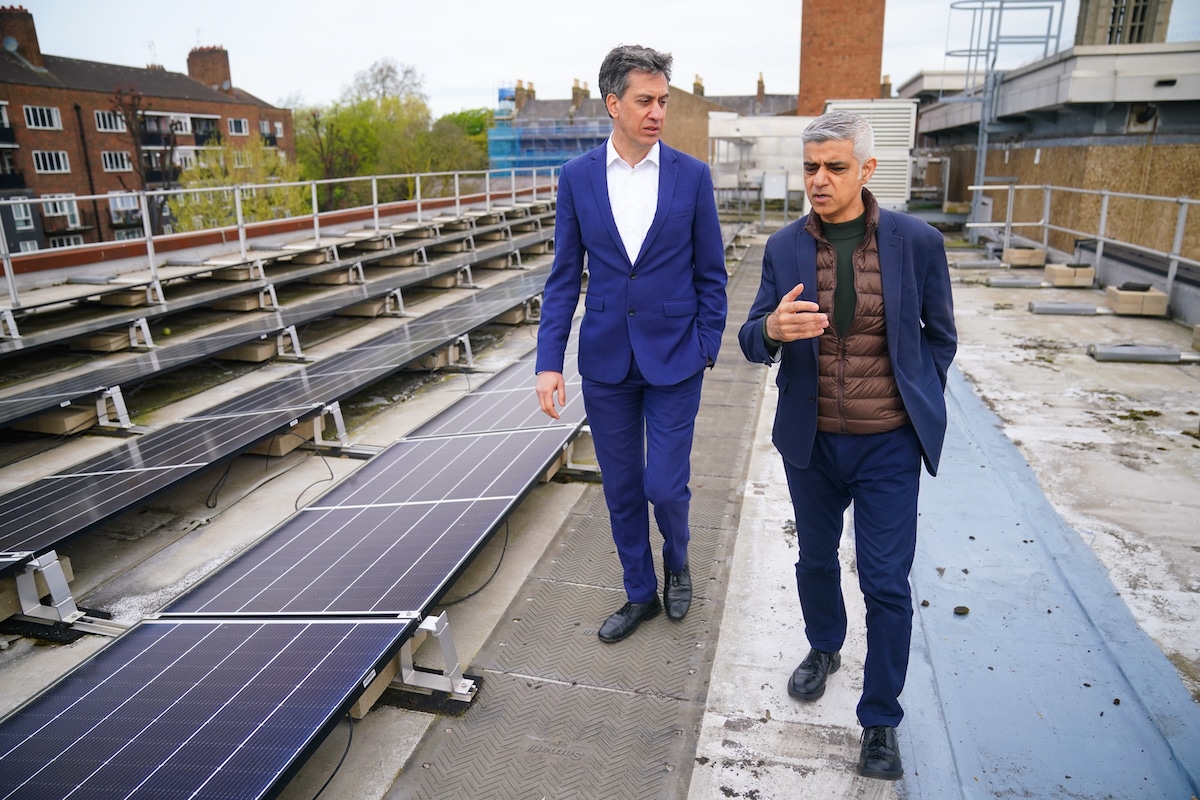 Mayor of London Sadiq Khan (right) and shadow energy secretary Ed Miliband walk past solar panels installed on the roof of Stoke Newington School in north London, during a visit to announce a new climate action plan for London